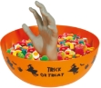 Oranžová halloweenská miska s vyčnívající šedou rukou, naplněná sladkostmi