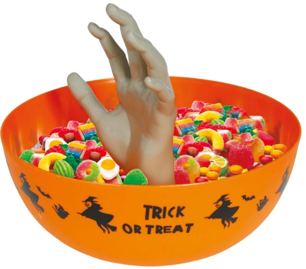 Oranžová halloweenská miska s vyčnívající šedou rukou, naplněná sladkostmi