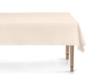 Béžový plastový ubrus 137 × 183 cm rozprostřený na stole