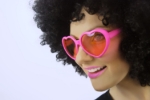 Modelka s růžovými brýlemi srdce jako výrazný doplněk na party