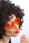 Modelka s červenými brýlemi srdce jako výrazný doplněk na Valentýn a party