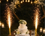 Dortová fontána se zlatými jiskrami zapíchnutá v svatebním dortu